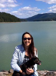 Photo of Lacey Guest with her dog in front of a lake